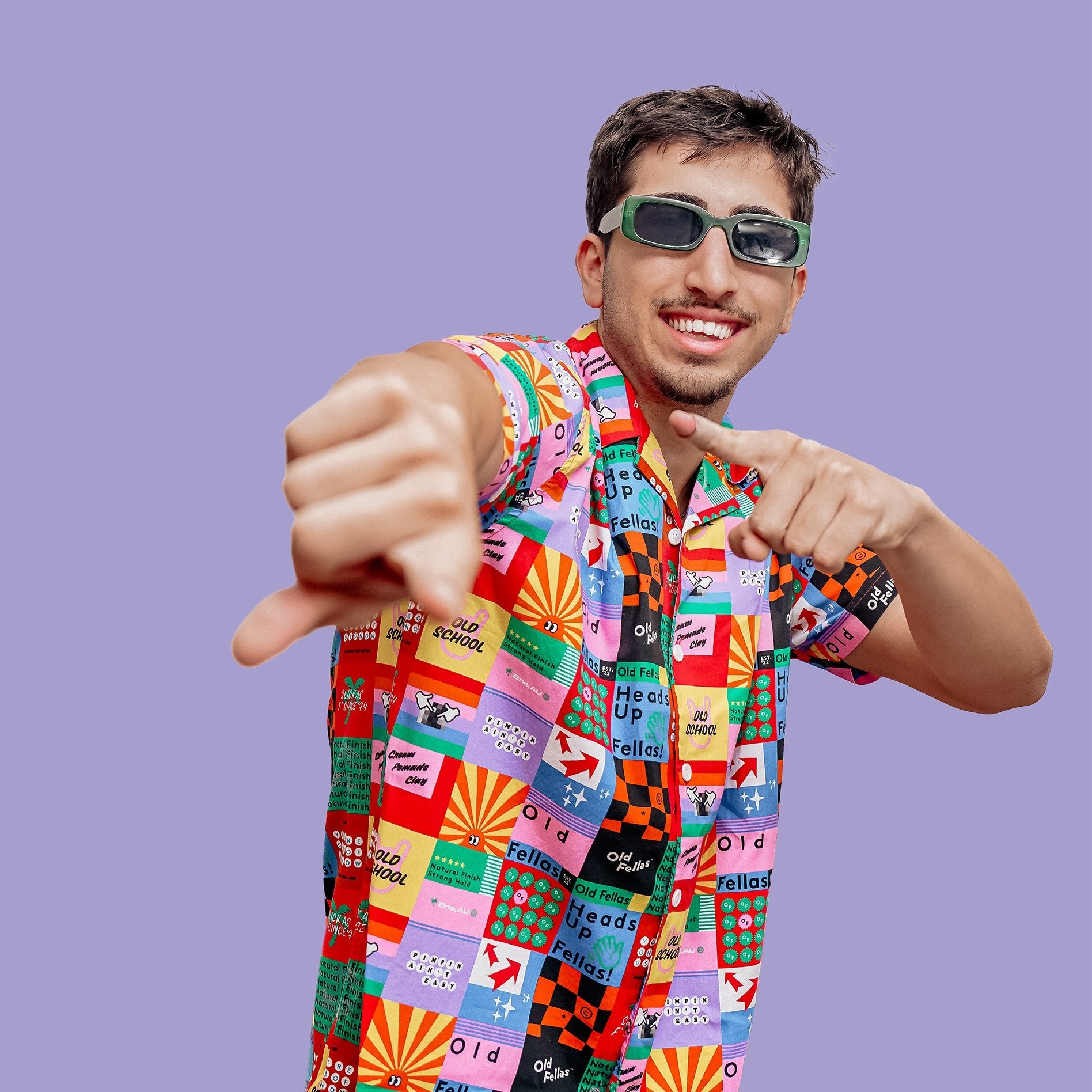 A young man wearing a vibrant multicoloured shirt and sunglasses, showcasing trendy hairstyle, unique fashion and urban lifestyle.